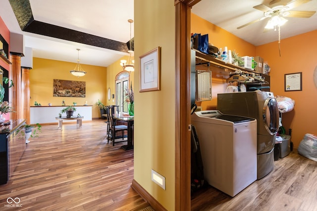 laundry room with washing machine and clothes dryer, wood finished floors, ceiling fan, baseboards, and laundry area