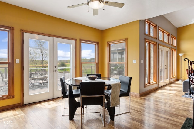 dining area featuring light wood-style floors, a wealth of natural light, ceiling fan, and french doors