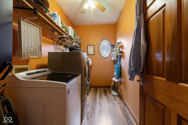 laundry area featuring laundry area, light wood-type flooring, baseboards, separate washer and dryer, and ceiling fan