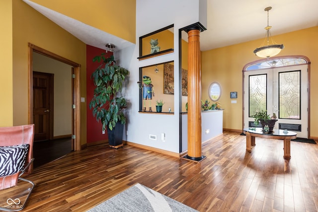 entryway with hardwood / wood-style floors, ornate columns, and baseboards