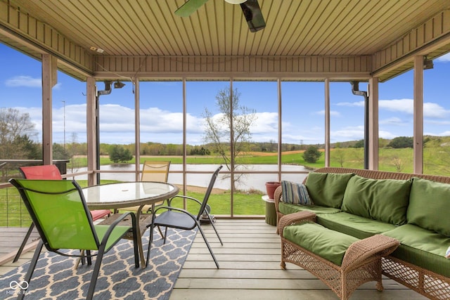 sunroom with an outdoor living space, a water view, and ceiling fan