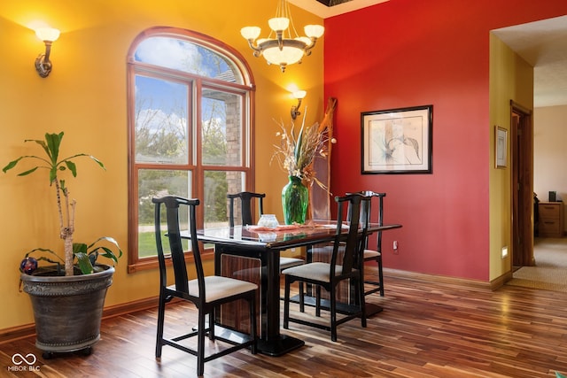 dining room with hardwood / wood-style flooring, baseboards, and an inviting chandelier