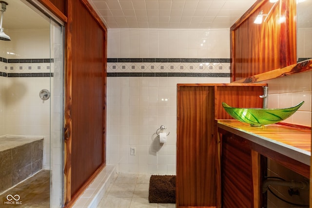 full bathroom with tile walls, vanity, tile patterned flooring, and a stall shower