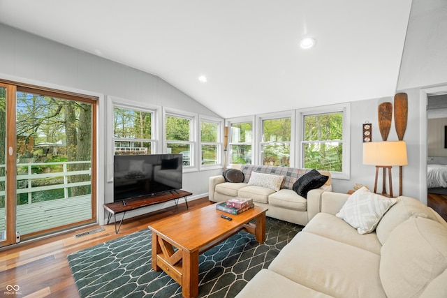living area with recessed lighting, vaulted ceiling, wood finished floors, and visible vents