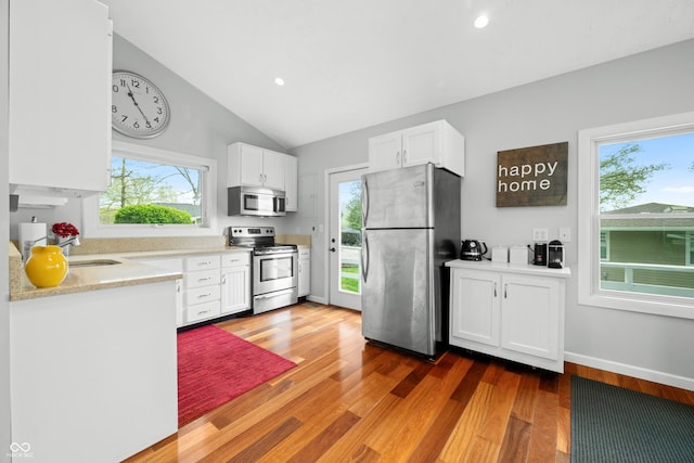 kitchen featuring stainless steel appliances, wood finished floors, and white cabinetry