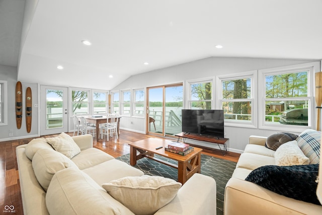 living room with baseboards, vaulted ceiling, and wood finished floors