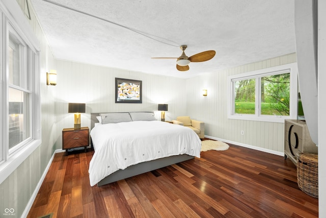 bedroom with baseboards, a ceiling fan, a textured ceiling, and wood finished floors
