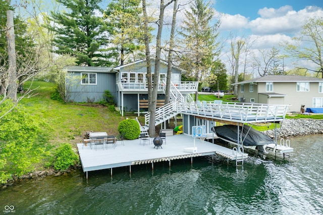 view of dock featuring stairs, a deck with water view, boat lift, a patio area, and a fire pit
