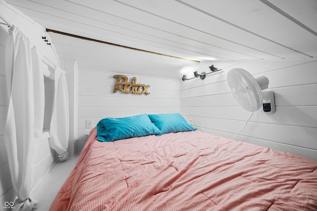 bedroom featuring wood walls and lofted ceiling
