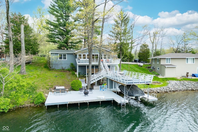 dock area with boat lift, a deck with water view, a patio, stairs, and a lawn