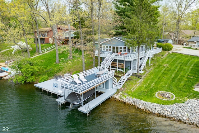 dock area with a yard, a deck with water view, and stairway