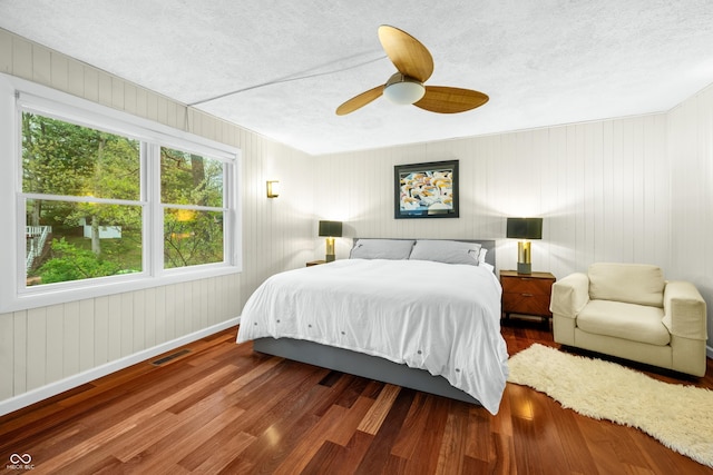 bedroom featuring visible vents, a textured ceiling, and wood finished floors