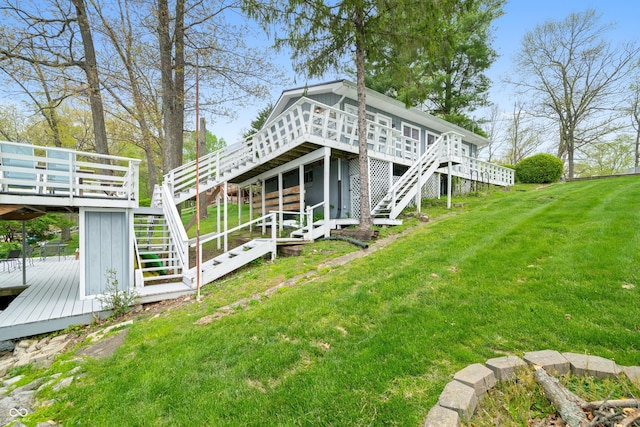 back of house with stairway, a yard, and a wooden deck