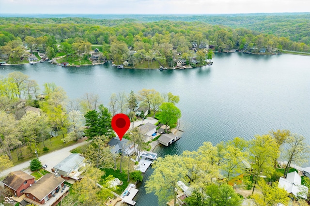 drone / aerial view with a forest view and a water view