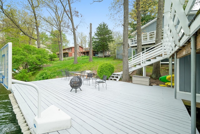 wooden terrace with a fire pit and stairway