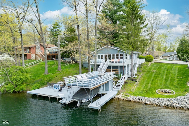 dock area with a deck with water view, a yard, and stairway