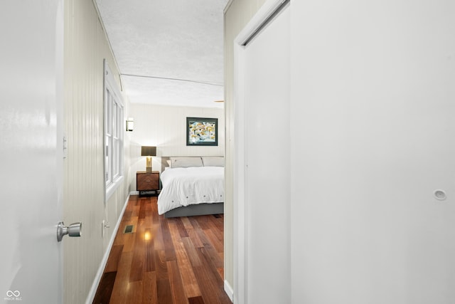 bedroom with baseboards, wood finished floors, and visible vents