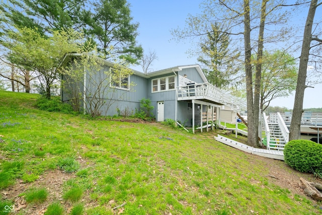 back of property with stairs, a yard, and a deck