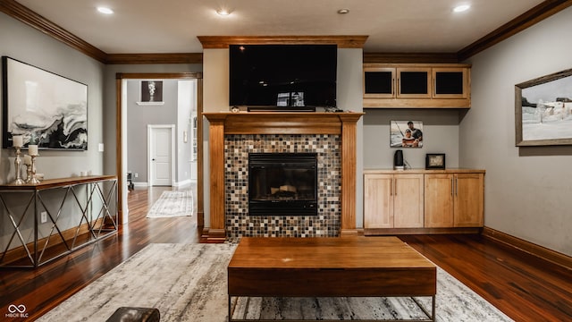 living room featuring recessed lighting, a tile fireplace, dark wood-type flooring, crown molding, and baseboards