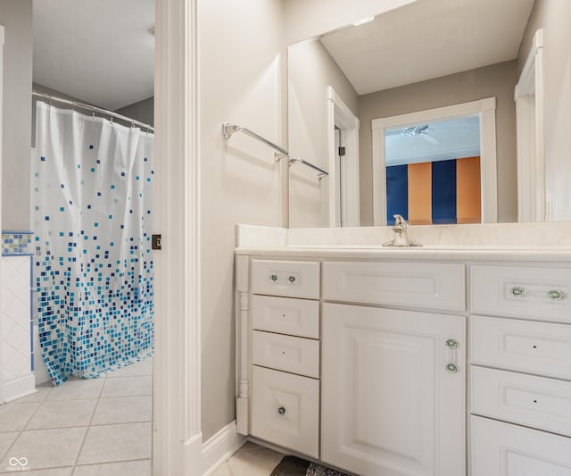 bathroom featuring tile patterned floors, vanity, baseboards, a shower with shower curtain, and ceiling fan