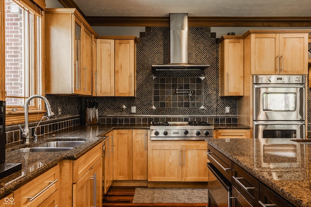 kitchen featuring a sink, dark stone counters, decorative backsplash, appliances with stainless steel finishes, and ornamental molding