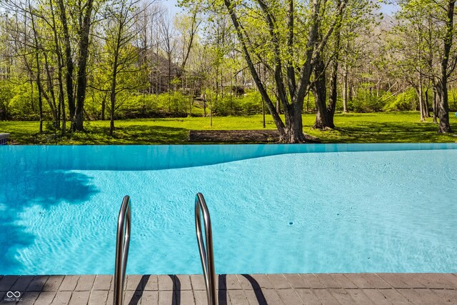 view of swimming pool with a yard