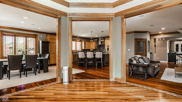 living area featuring crown molding, hardwood / wood-style floors, and plenty of natural light