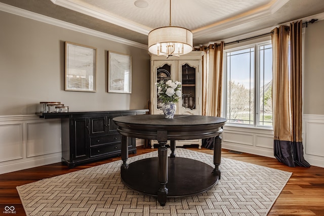 dining space featuring a decorative wall, crown molding, a raised ceiling, a notable chandelier, and visible vents