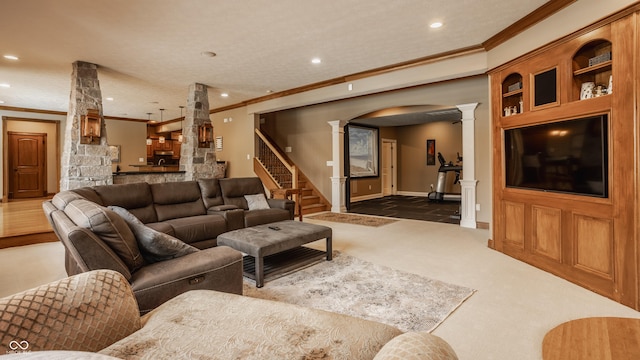 carpeted living room with arched walkways, crown molding, ornate columns, and recessed lighting