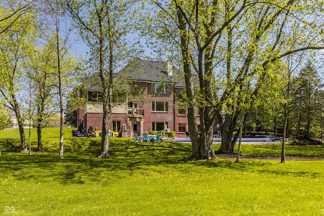 back of property with a lawn and brick siding