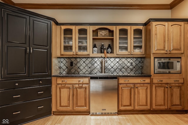 kitchen featuring appliances with stainless steel finishes, tasteful backsplash, crown molding, and light wood-style floors
