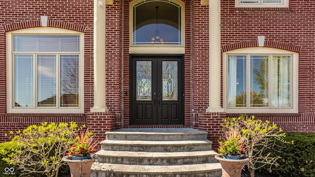 property entrance with brick siding and french doors