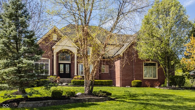 view of front of property featuring brick siding and a front yard
