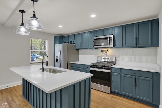 4775 E 56th St, Indianapolis, IN 46220 - kitchen featuring appliances with stainless steel finishes, light wood-style floors, blue cabinetry, and a sink