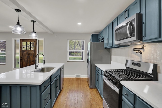 4775 E 56th St, Indianapolis, IN 46220 - kitchen featuring tasteful backsplash, appliances with stainless steel finishes, light countertops, a sink, and visible vents