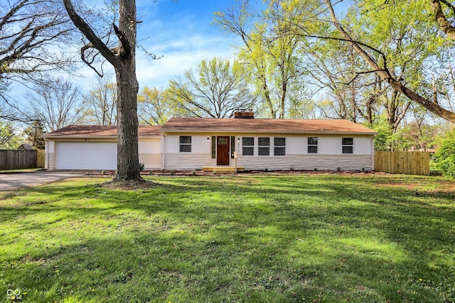 4775 E 56th St, Indianapolis, IN 46220 - ranch-style house with a chimney, stone siding, aphalt driveway, and fence