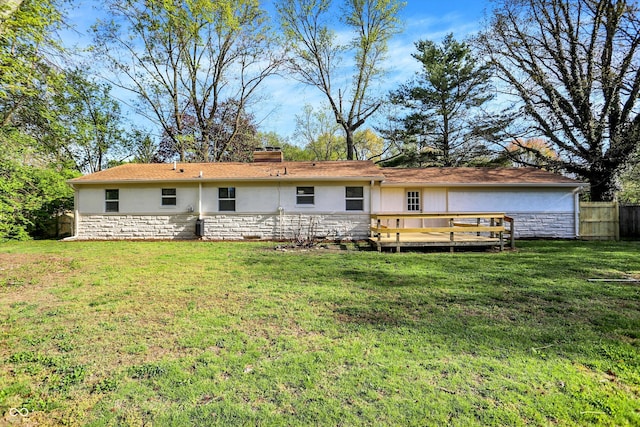 4775 E 56th St, Indianapolis, IN 46220 - back of property with fence, a lawn, a wooden deck, and stone siding