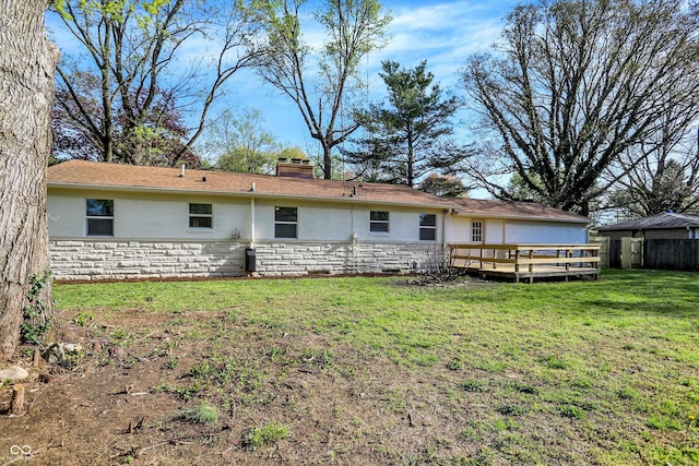4775 E 56th St, Indianapolis, IN 46220 - back of house featuring a chimney, a yard, fence, a wooden deck, and stone siding