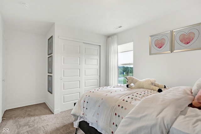 carpeted bedroom with visible vents, baseboards, and a closet