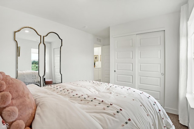 bedroom with a closet, visible vents, and carpet