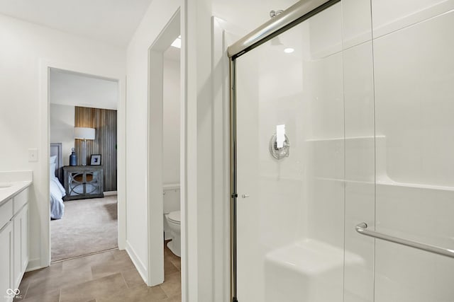 full bath featuring toilet, a stall shower, vanity, and ensuite bathroom