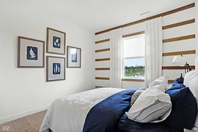 carpeted bedroom featuring visible vents and baseboards