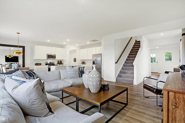 living room with visible vents, recessed lighting, light wood finished floors, and stairs