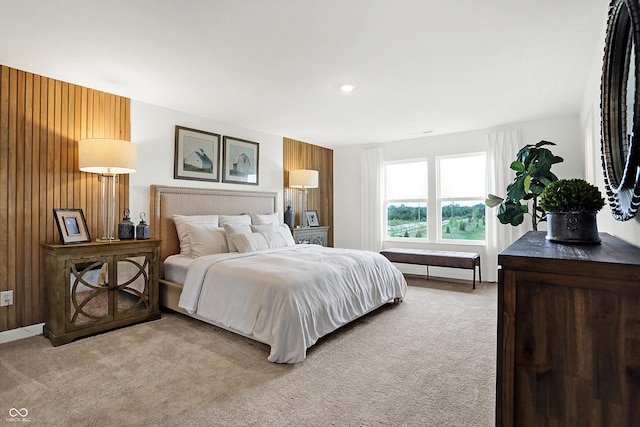 bedroom featuring wood walls and light carpet