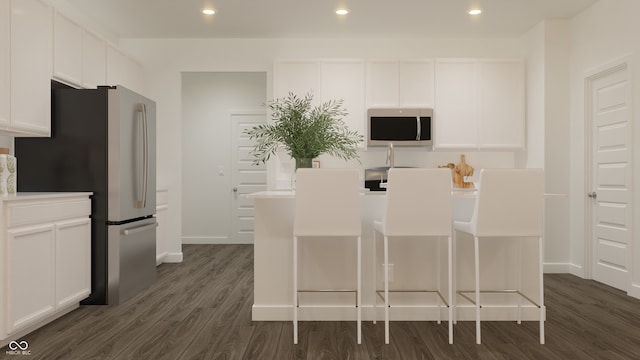 kitchen with dark wood finished floors, baseboards, appliances with stainless steel finishes, and white cabinets