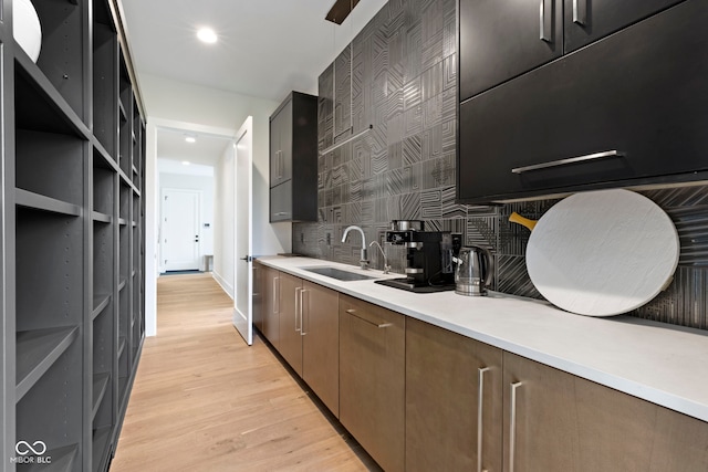 1333 Chatham Rdg Ct, Westfield, IN 46074 - kitchen featuring a sink, light wood-style floors, light countertops, recessed lighting, and decorative backsplash