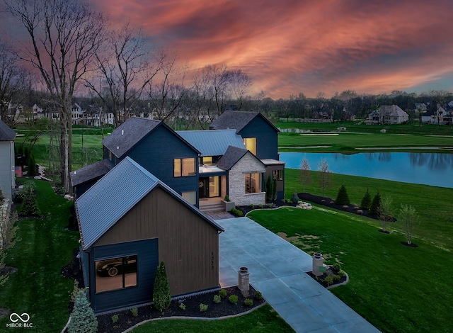 1333 Chatham Rdg Ct, Westfield, IN 46074 - view of front facade with a water view, a front lawn, stone siding, and metal roof