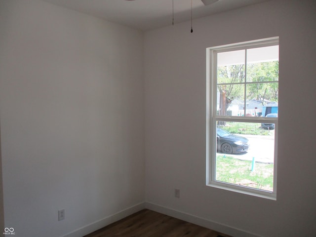 unfurnished room featuring dark wood-type flooring, baseboards, and ceiling fan