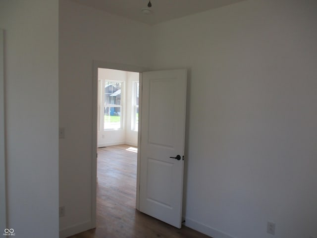 spare room with dark wood-style flooring and baseboards