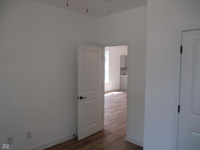 empty room featuring wood finished floors, baseboards, and a ceiling fan